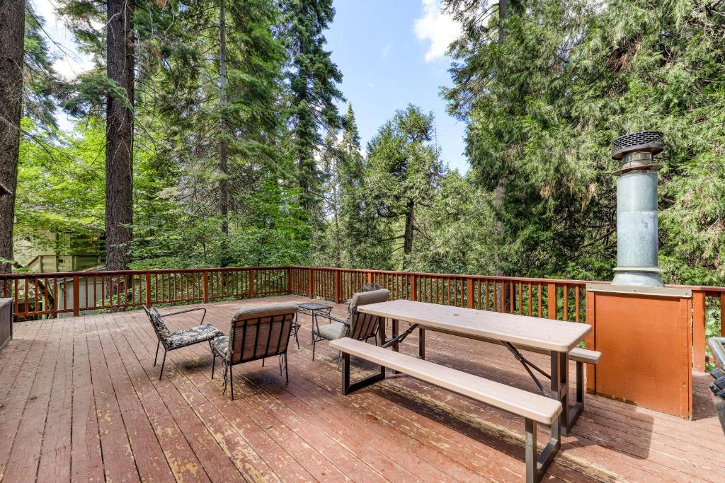 a wooden deck with a picnic table and chairs at Bullwinkle's Place in Shaver Lake