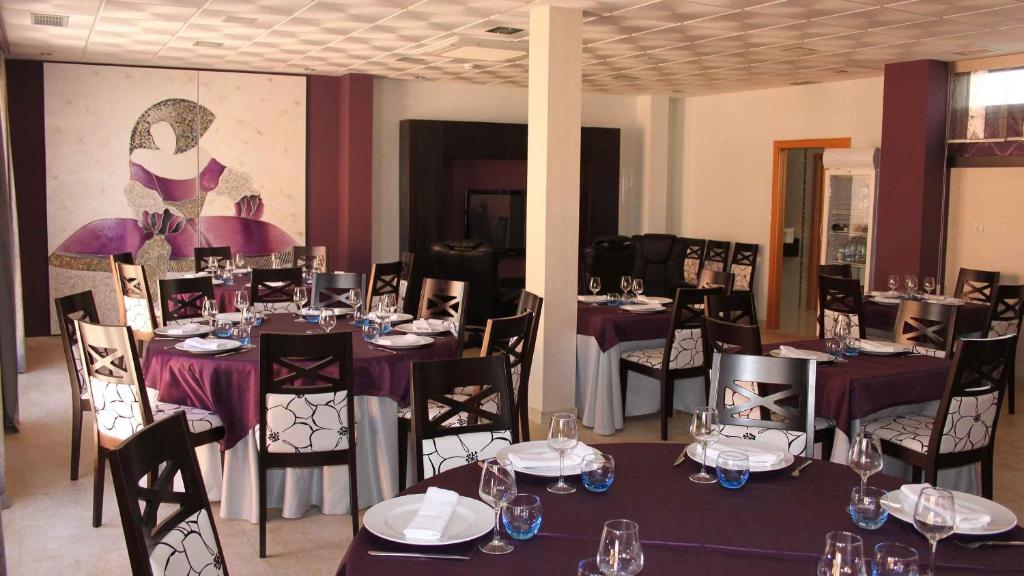 a dining room with tables and chairs with wine glasses at Hotel Rural Casa Ramiro in Cedrillas