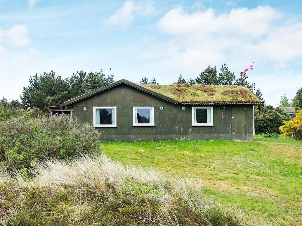 a house with a grass roof on a field at 6 person holiday home in R m in Bolilmark