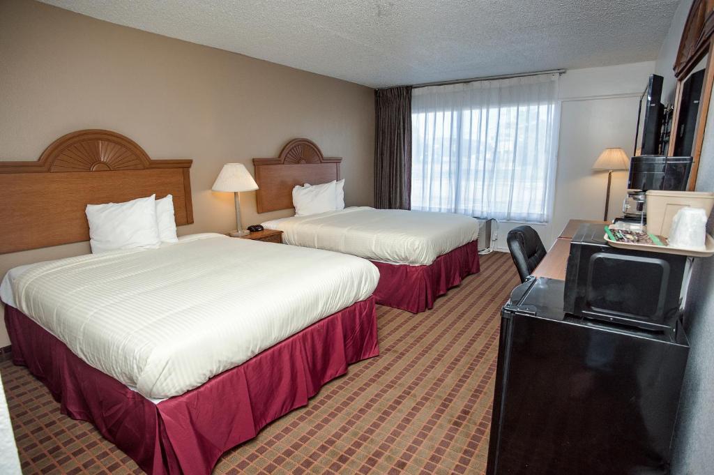 グリーンビルにあるExpress Inn & Suitesのベッド2台とテレビが備わるホテルルームです。