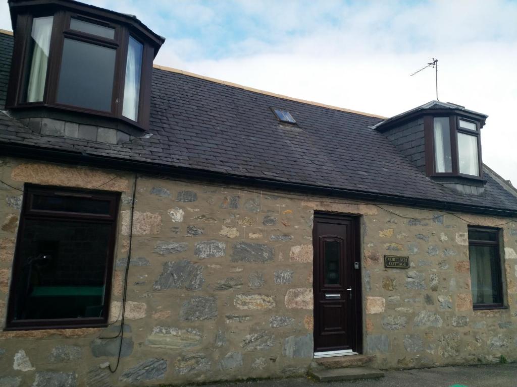 a stone building with two windows on top of it at Mortlach Cottage in Dufftown