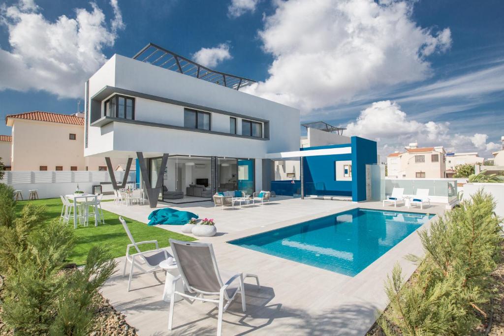 a villa with a swimming pool and a house at Colour Residences in Protaras