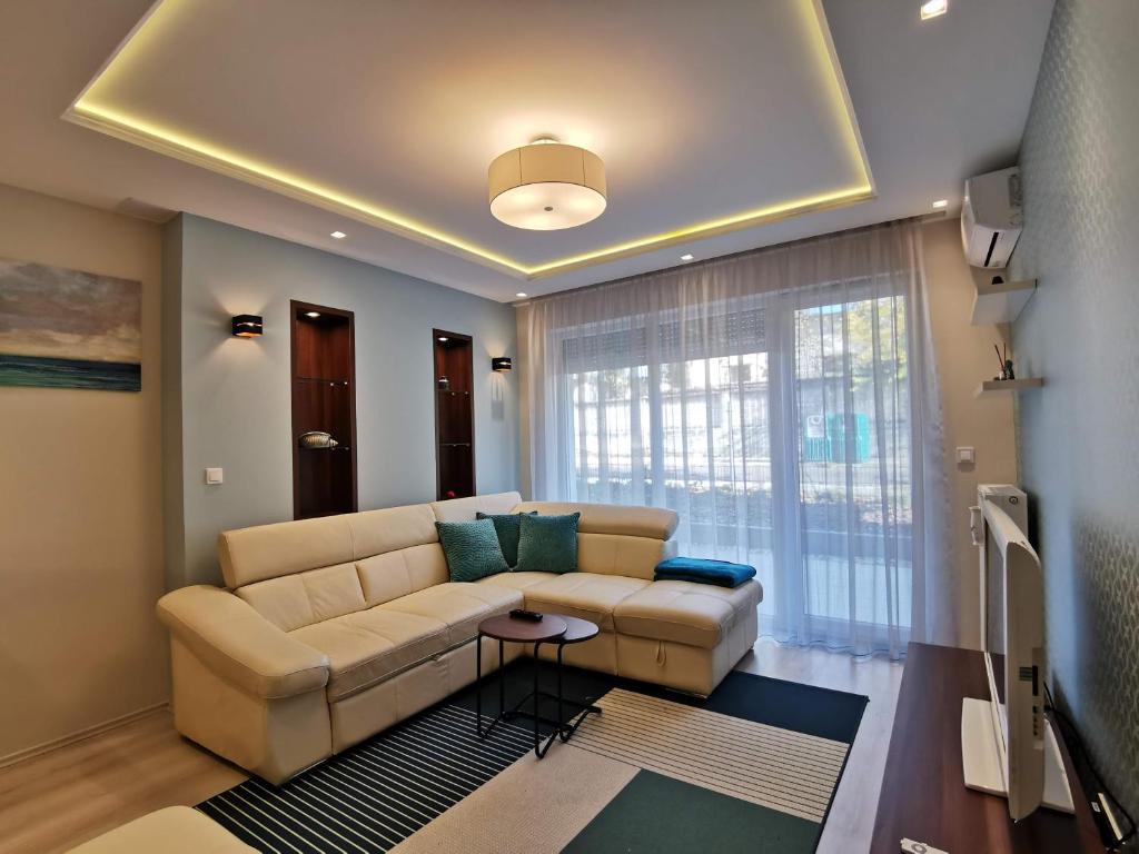 a living room with a couch and a large window at Luna apartment in Budapest