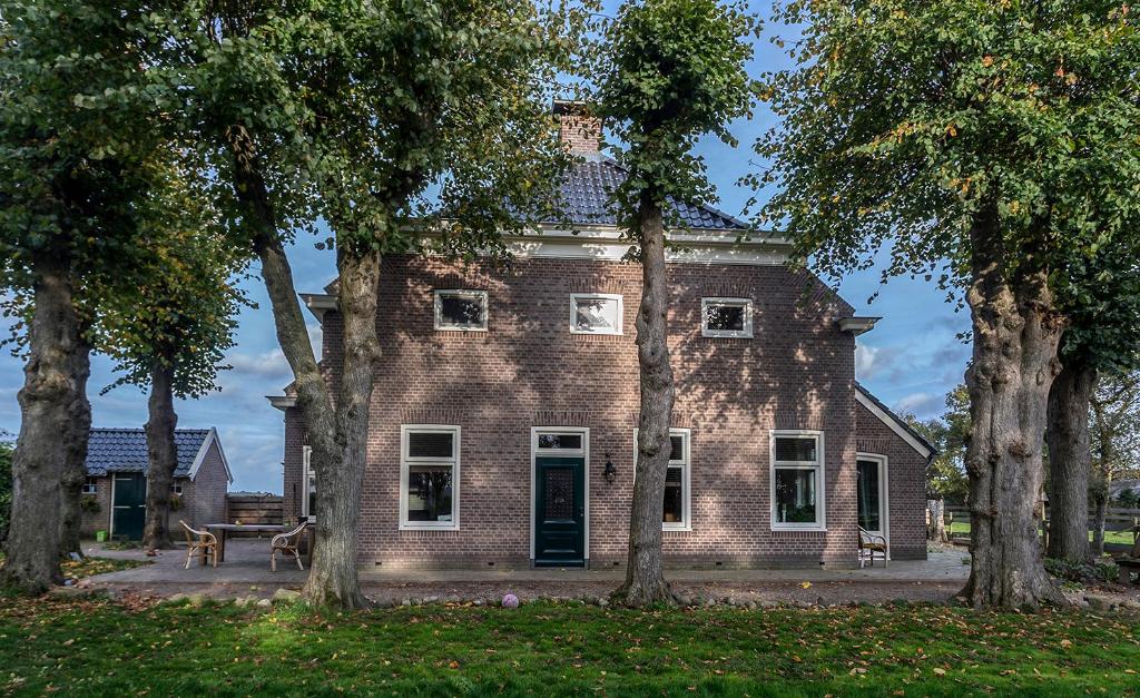 an old brick house with trees in front of it at van Abelshoeve in Gieterveen