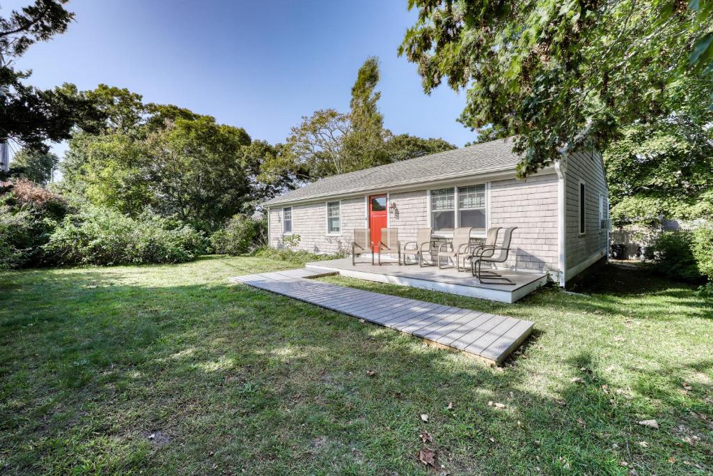 a house with a deck and a red door at Winthrop Cottage in Oak Bluffs