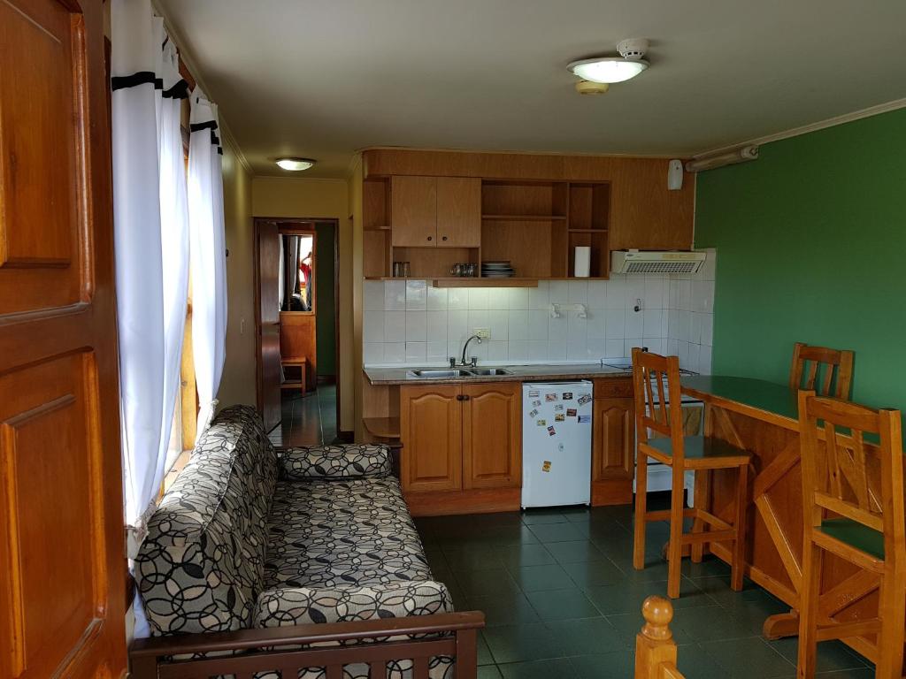 a kitchen with a couch and a kitchen with a counter at Apart Hotel Alem in Ushuaia