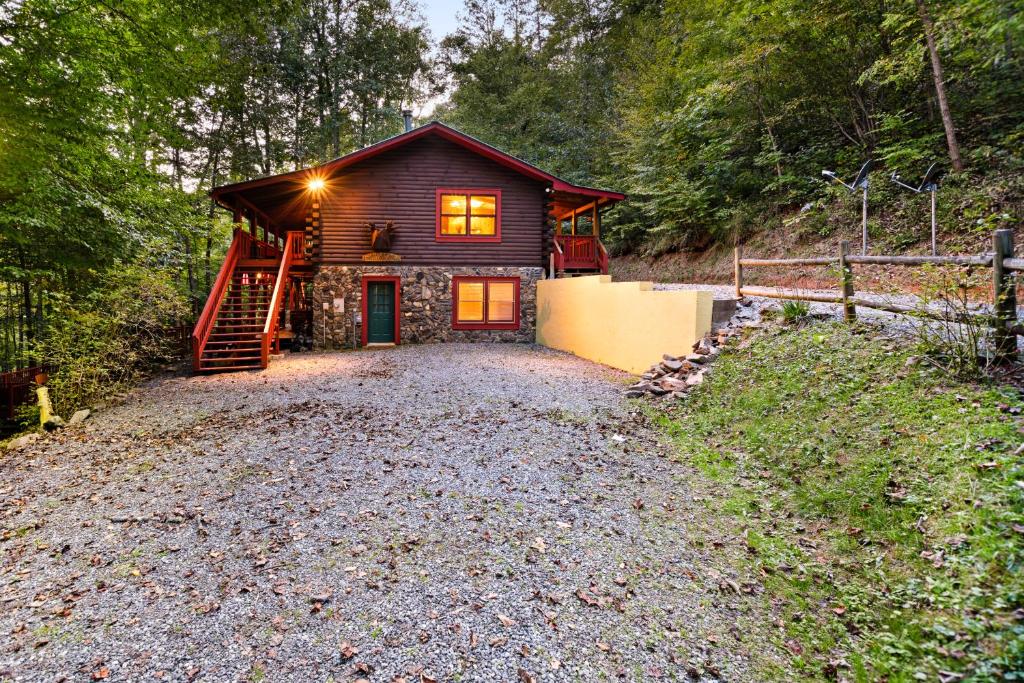 a cabin in the woods with a gravel driveway at Moose Creek Lodge in Sylva