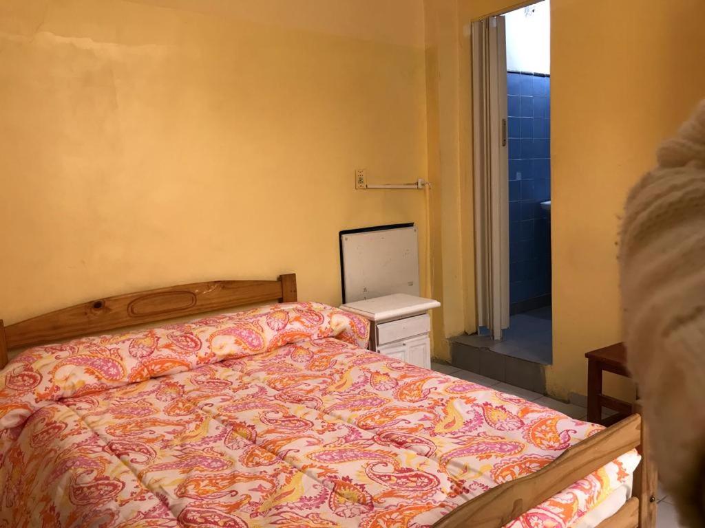 um quarto com uma cama e uma porta para uma casa de banho em Mitre Suites em Buenos Aires