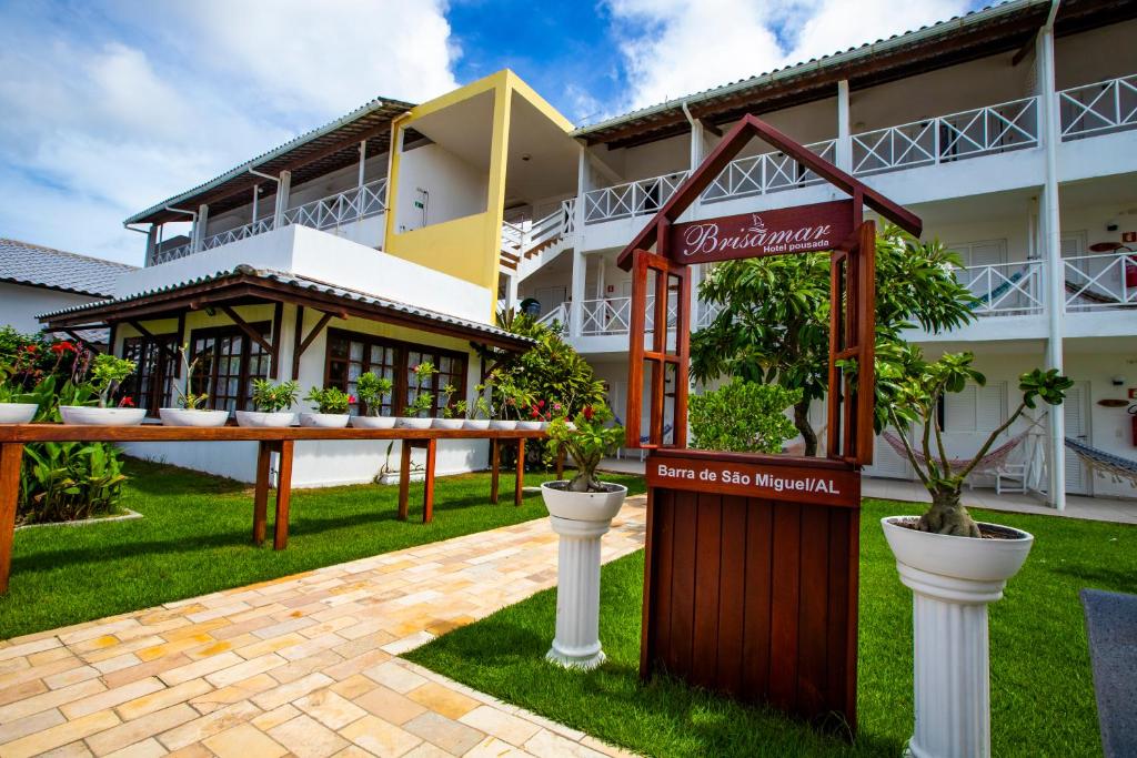 ein Gebäude mit einem Schild davor in der Unterkunft Brisamar Hotel Pousada in Barra de São Miguel