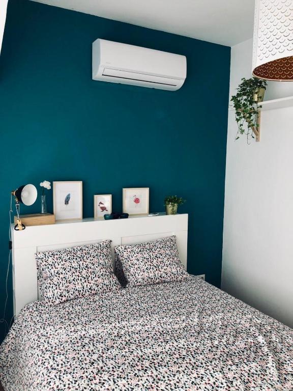 a bedroom with a blue wall and a bed with a white headboard at Blue Flamingo Apartment in Torremolinos