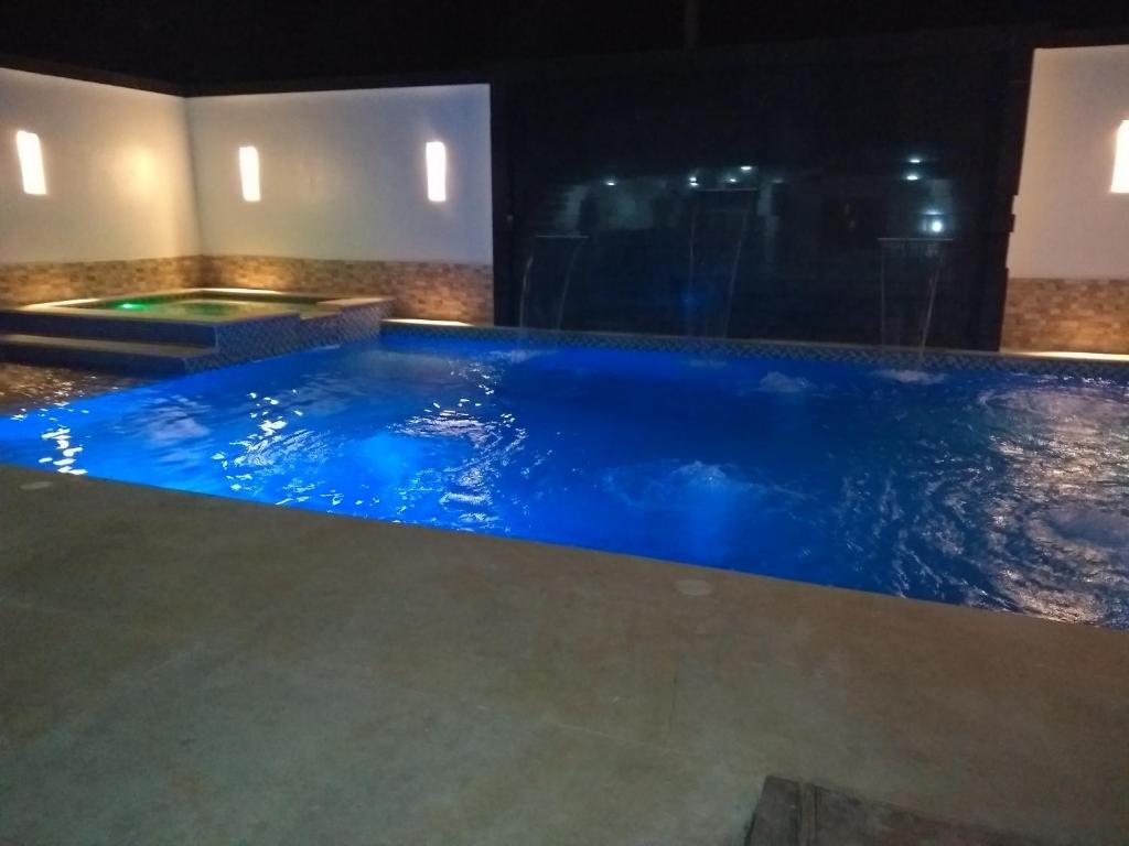 a pool with blue water in a room at Hospedaje casa Lucía in Leticia