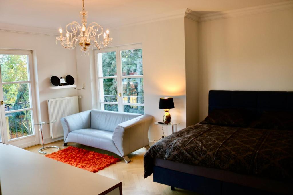 una camera da letto con un letto, una sedia e un lampadario di Villa am Steinhuder Meer Superior DZ-Azur- mit kl Pantry Küche, Garten, WLAN a Steinhude