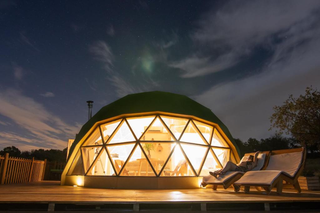 a large glass dome with a couple of chairs in it at Domo en Montes de Toledo in Mazarambroz