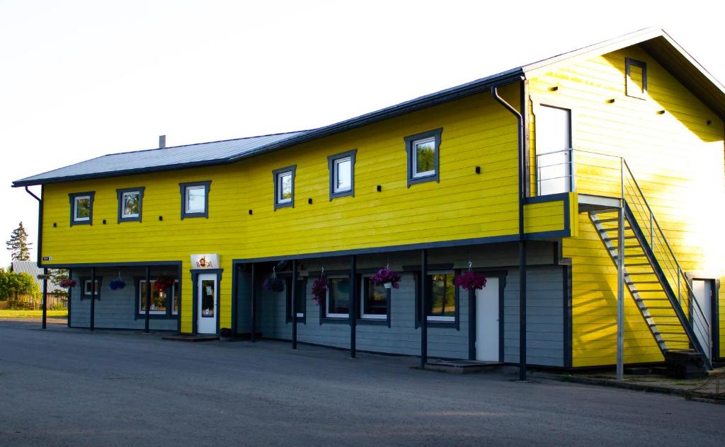 a yellow building with stairs on the side of it at OXCafe Hostel in Kose-Uuemõisa