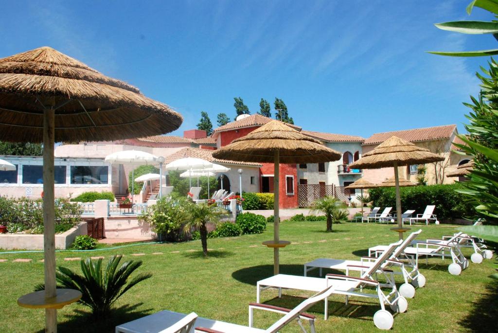 a group of chairs and umbrellas in a yard at Hotel Stefania Boutique Hotel by the Beach in Olbia