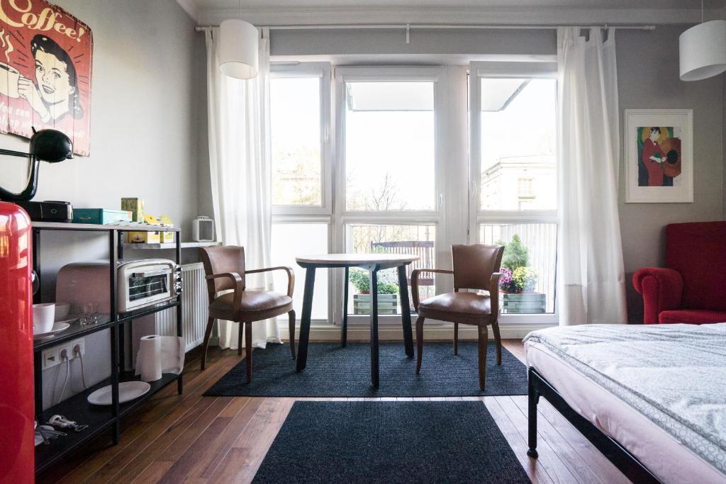 1 dormitorio con mesa, sillas y 1 cama en Saskasummer en Varsovia