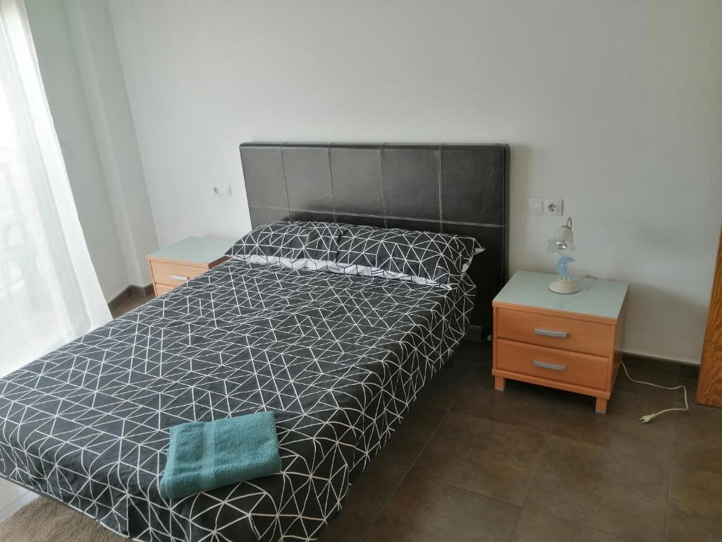 アルカンタリージャにあるApartamento Príncipeのベッドルーム1室(ベッド1台、白黒の掛け布団付)