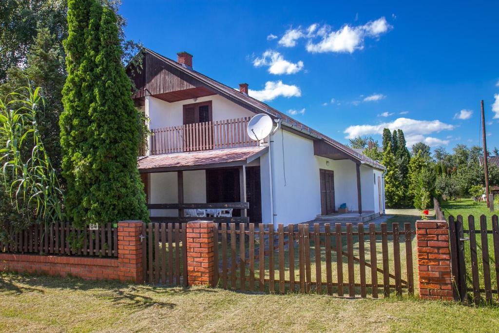 ein Haus mit einem Zaun davor in der Unterkunft Familia nyaraló 16 in Balatonmáriafürdő