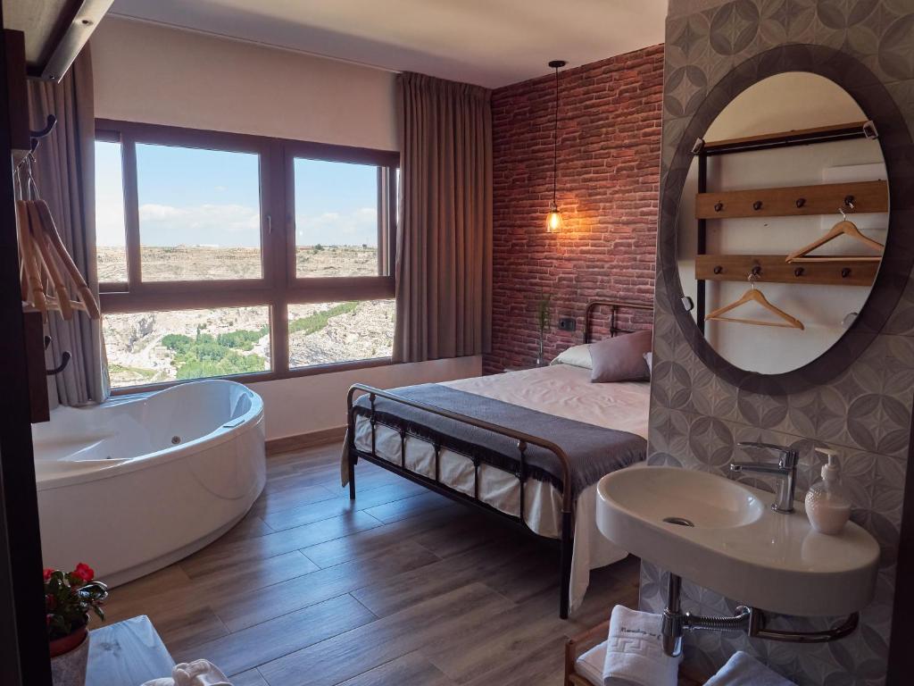 a bedroom with a bed and a tub and a sink at Morada 2 in Casas del Cerro