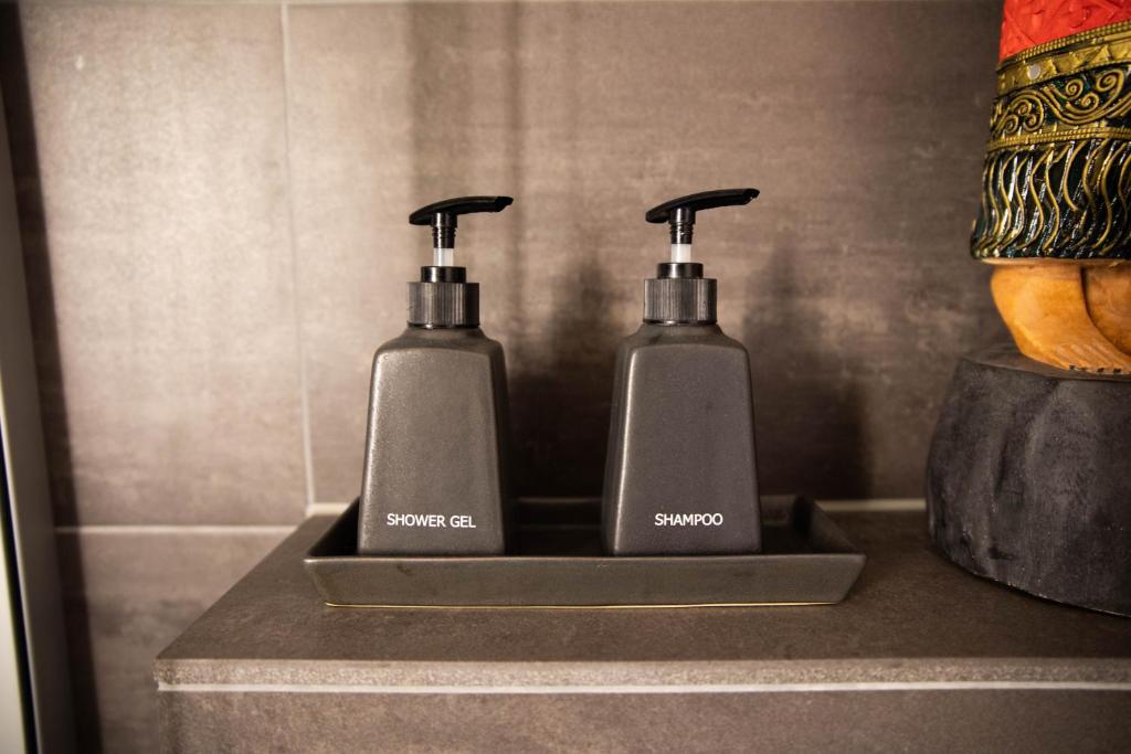 two soap dispensers are sitting on a counter at Luxury loft on top of Villa Wilen with tremendous views by the lake in Sarnen