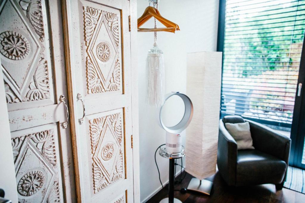 a room with a chair and a mirror next to a door at Luxury loft on top of Villa Wilen with tremendous views by the lake in Sarnen