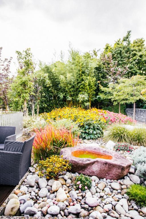 a garden with a fountain in the middle at Luxury loft on top of Villa Wilen with tremendous views by the lake in Sarnen