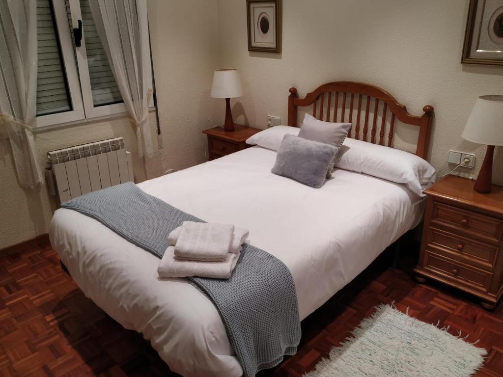 een slaapkamer met een bed met twee handdoeken erop bij APARTAMENTO CENTRO GIJON Vut1703AS in Gijón