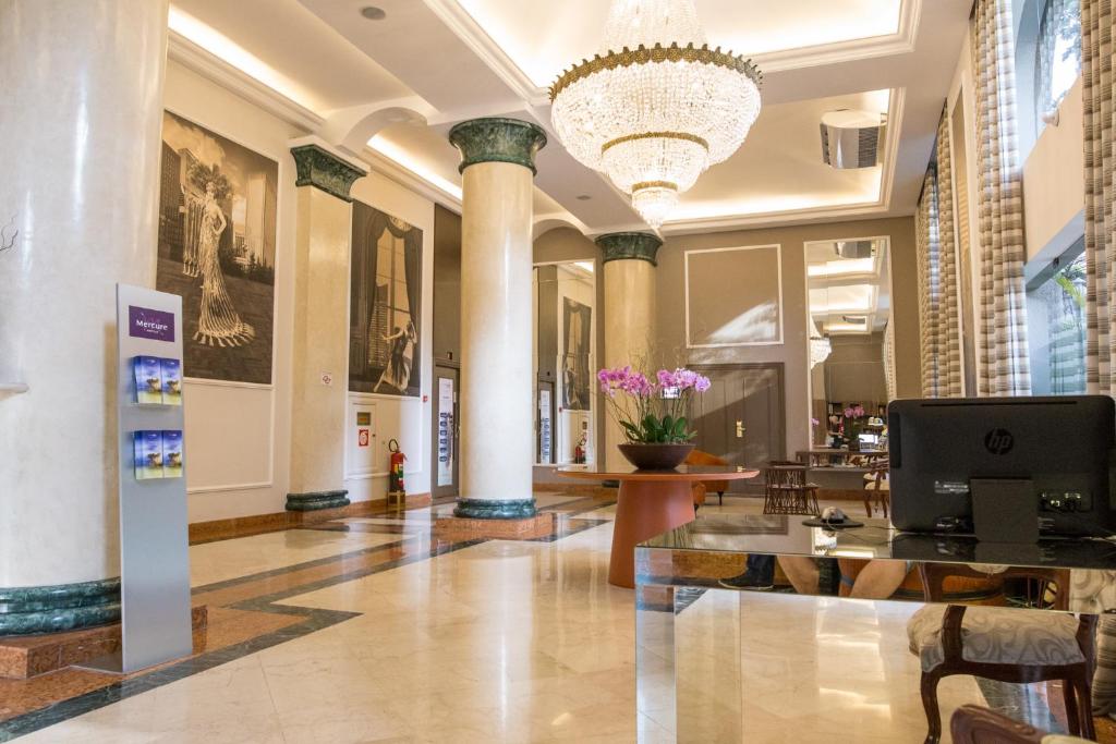 a lobby of a building with columns and a chandelier at EXCELENTE Flat junto aos Shoppings JK e Vila Olimpia in Sao Paulo