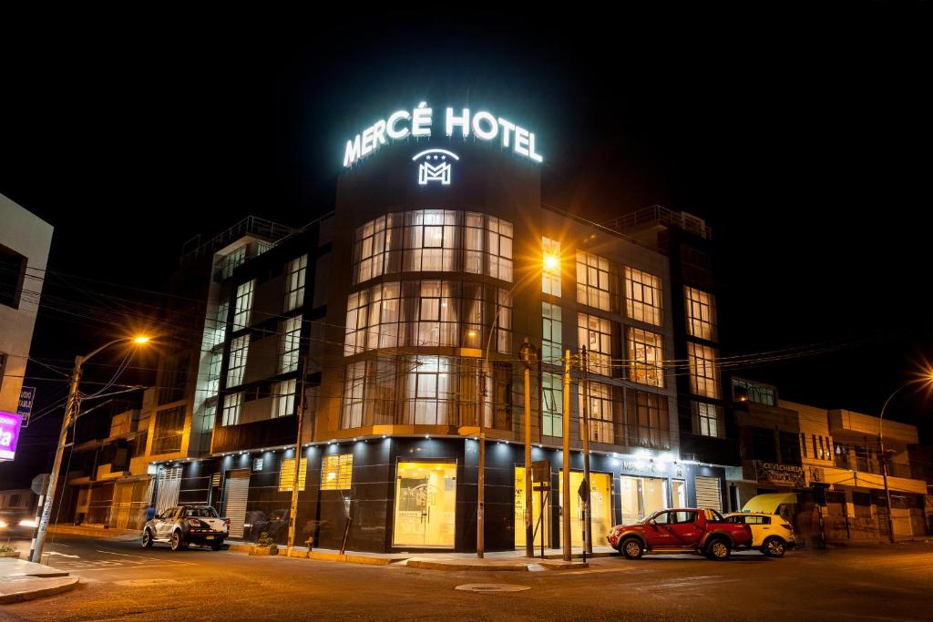 a large building with a sign on it at night at Mercé Hotel in Tacna