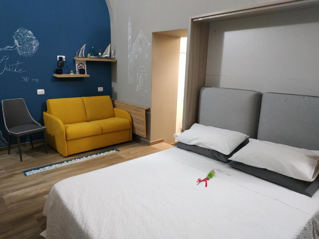 una camera con un letto bianco e un divano giallo di Suite 30 mq a Palo del Colle