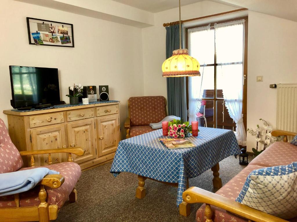 貝希特斯加登的住宿－FeWo Bergglück，客厅配有桌子和电视