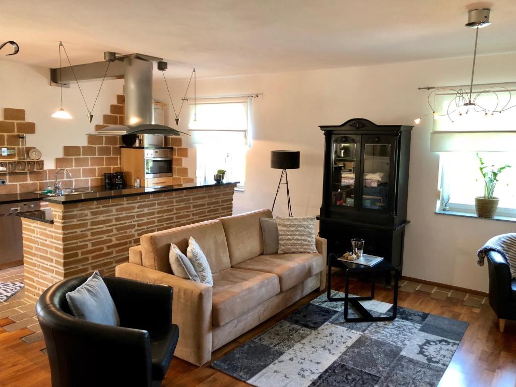 a living room with a couch and a brick wall at Ferienwohnung Fam.Stuchlik in Winkl