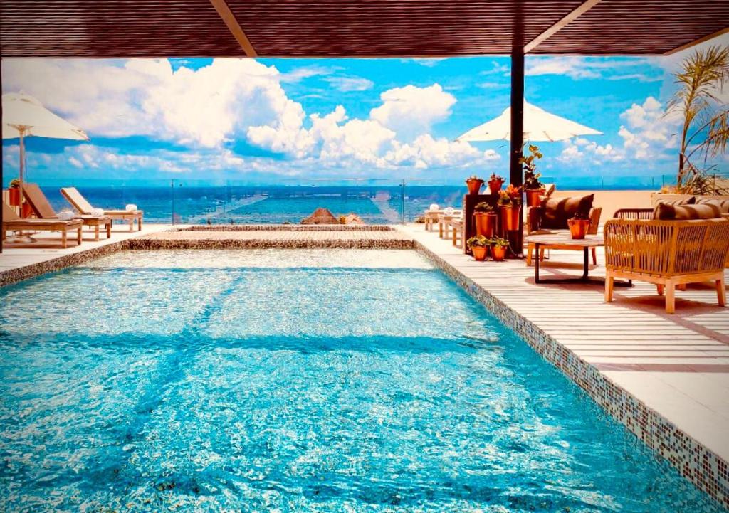 una piscina con vistas al océano en Singular Joy Downtown Residences en Playa del Carmen