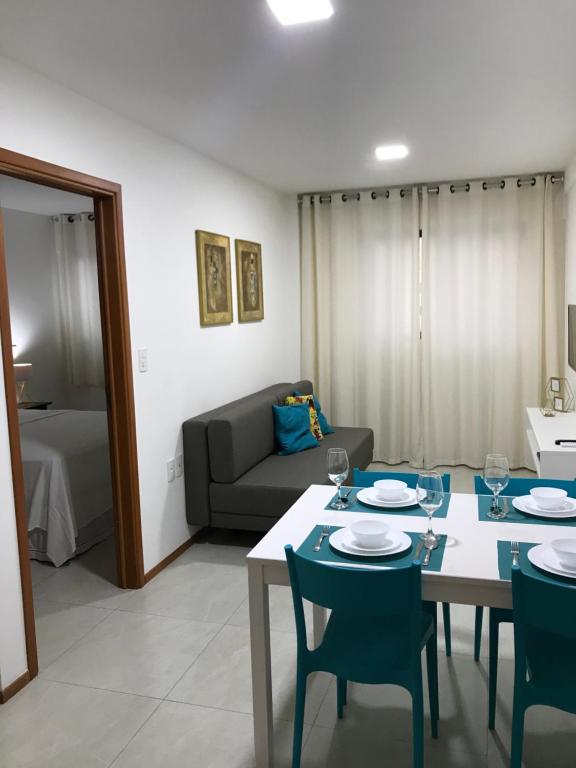 a living room with a table and chairs and a couch at Apartamento Completo Jatiúca in Maceió