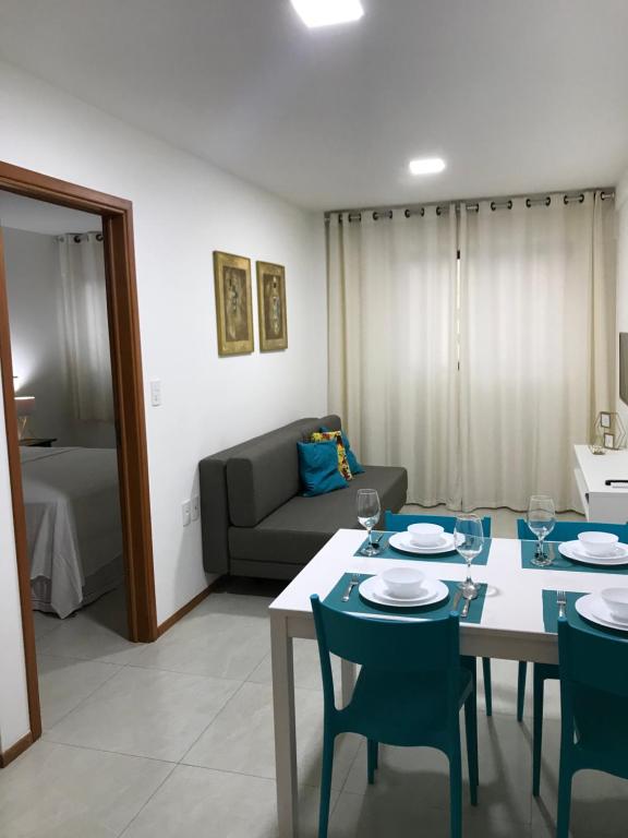 uma sala de estar com uma mesa e cadeiras e um sofá em Apartamento Completo Jatiúca em Maceió