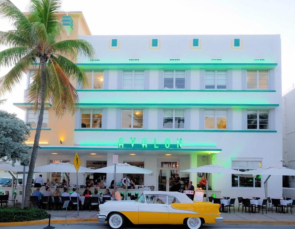 een oude auto geparkeerd voor een hotel bij Avalon Hotel in Miami Beach