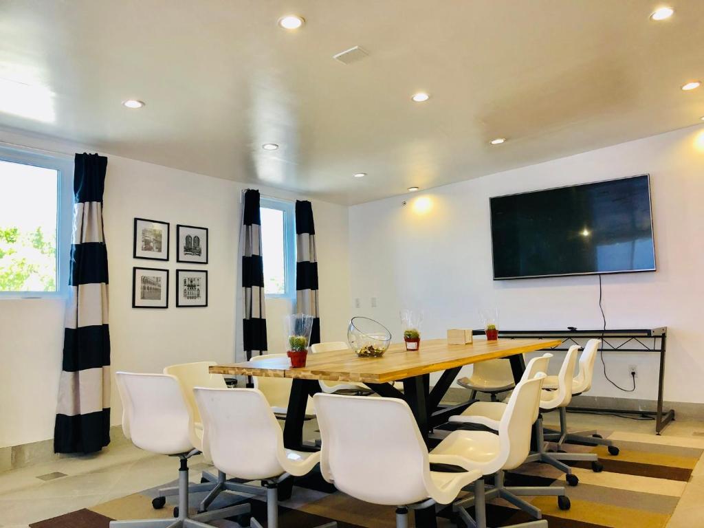 a conference room with a wooden table and white chairs at Culver City Hostel in Los Angeles