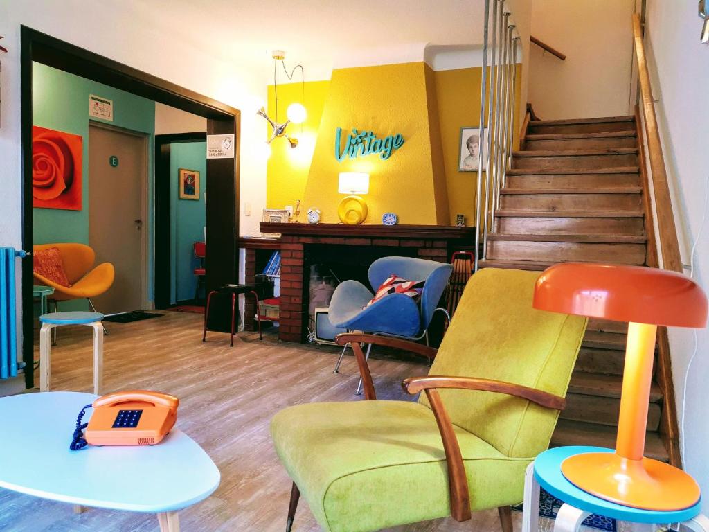 una habitación con sillas, mesas y una escalera en Vintage Bariloche Hostel Boutique en San Carlos de Bariloche