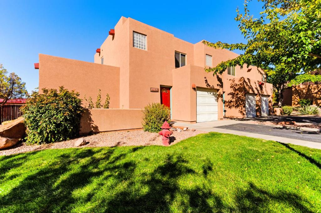 a brick house with a red door and a yard at Solano Vallejo 3283 in Moab