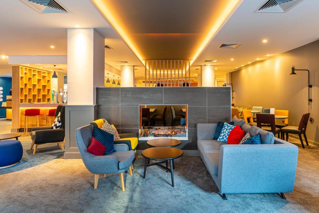 a living room with two couches and a fireplace at Holiday Inn Express - Derry - Londonderry by IHG in Derry Londonderry