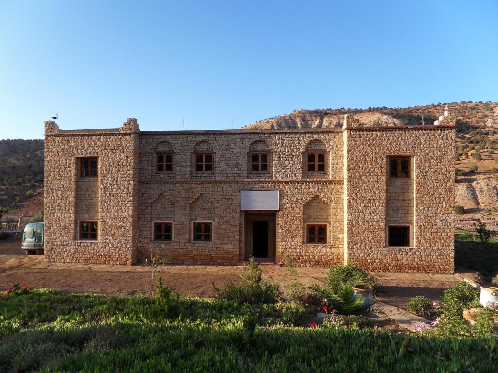 un vieux bâtiment en briques avec des fenêtres dans une cour dans l'établissement Maison d'Hôtes Agdal Telouet, à Tiguidert
