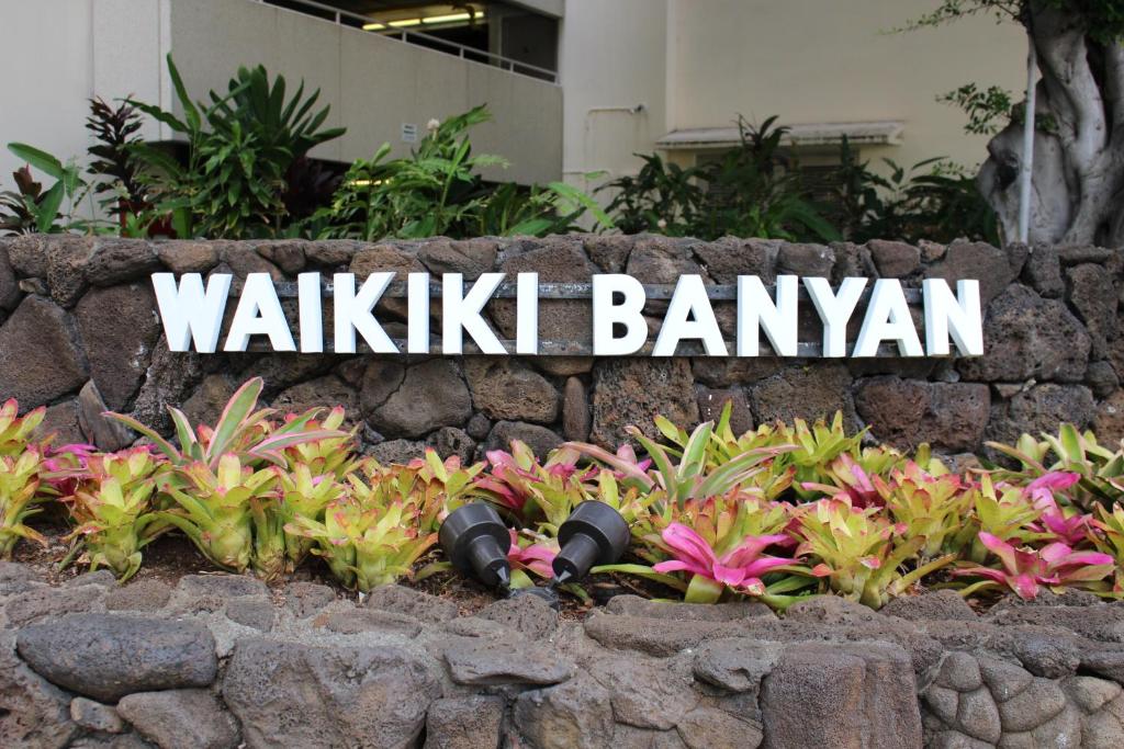 a sign that reads walkik bang kanatown with pink flowers at PonoAloha in Honolulu