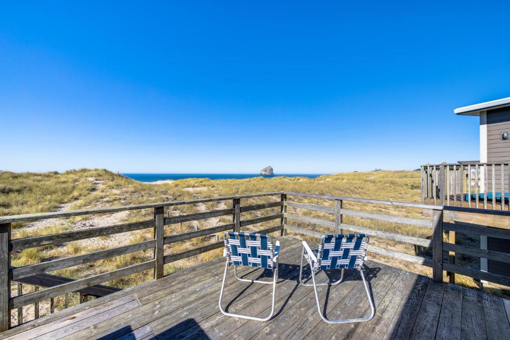 - deux chaises assises sur une terrasse donnant sur l'océan dans l'établissement Ocean Front Sunsets, à Pacific City