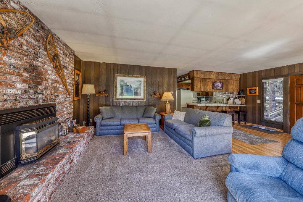 a living room with blue furniture and a brick wall at Water's Edge Retreat in Shaver Lake