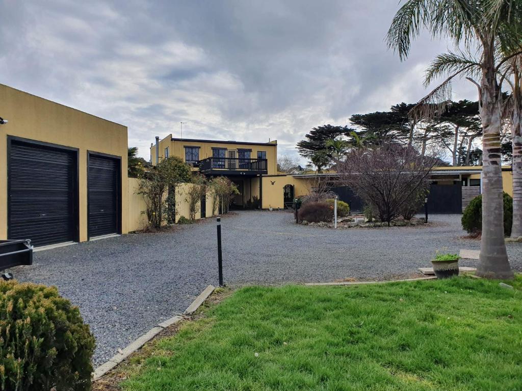 a large yellow house with a gravel driveway at Chateau Bass in Bass