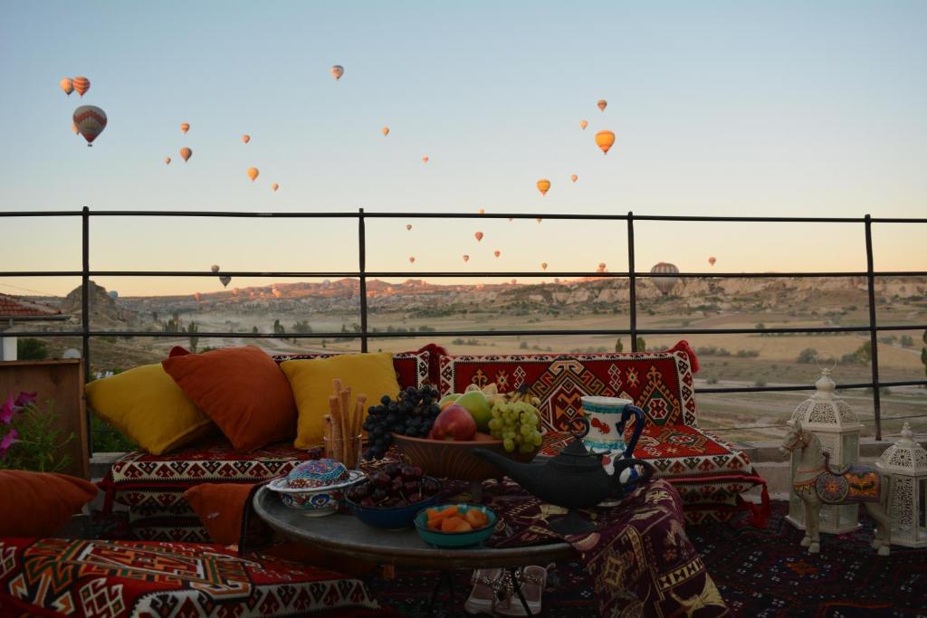 Prime Cappadocia Suites في نوشهر: غرفة معيشة مع أريكة وطاولة مع فاكهة
