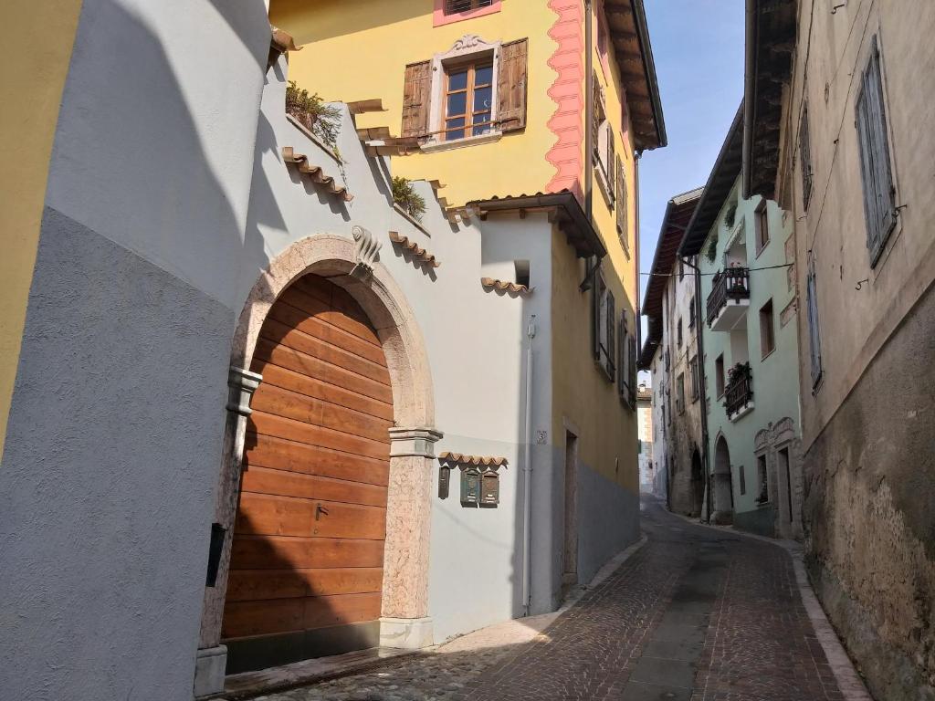 an alley in an old town with a wooden door at Casa di Patrizia in Calavino