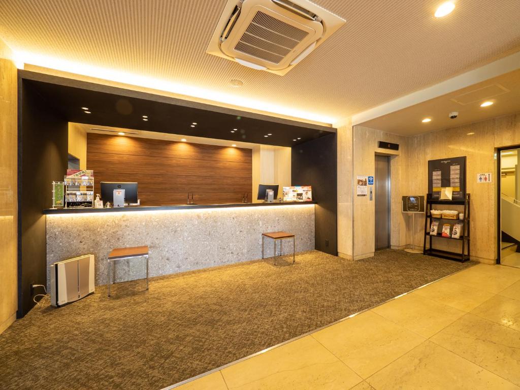 a lobby with a bar with two stools in it at Kusatsu Daiichi Hotel in Kusatsu
