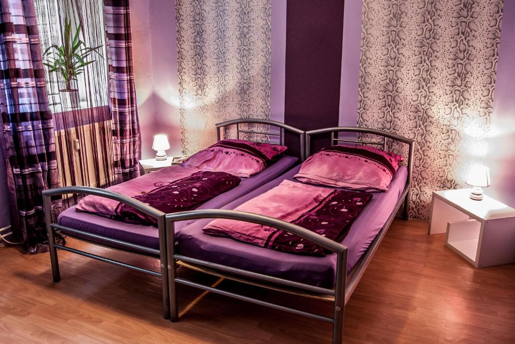1 Schlafzimmer mit 2 Betten und rosa Bettwäsche in der Unterkunft Paulibude in Hamburg