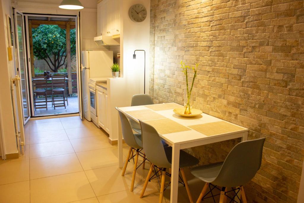 a dining room table with chairs and a brick wall at Cozy Studio in Central Glyfada in Athens